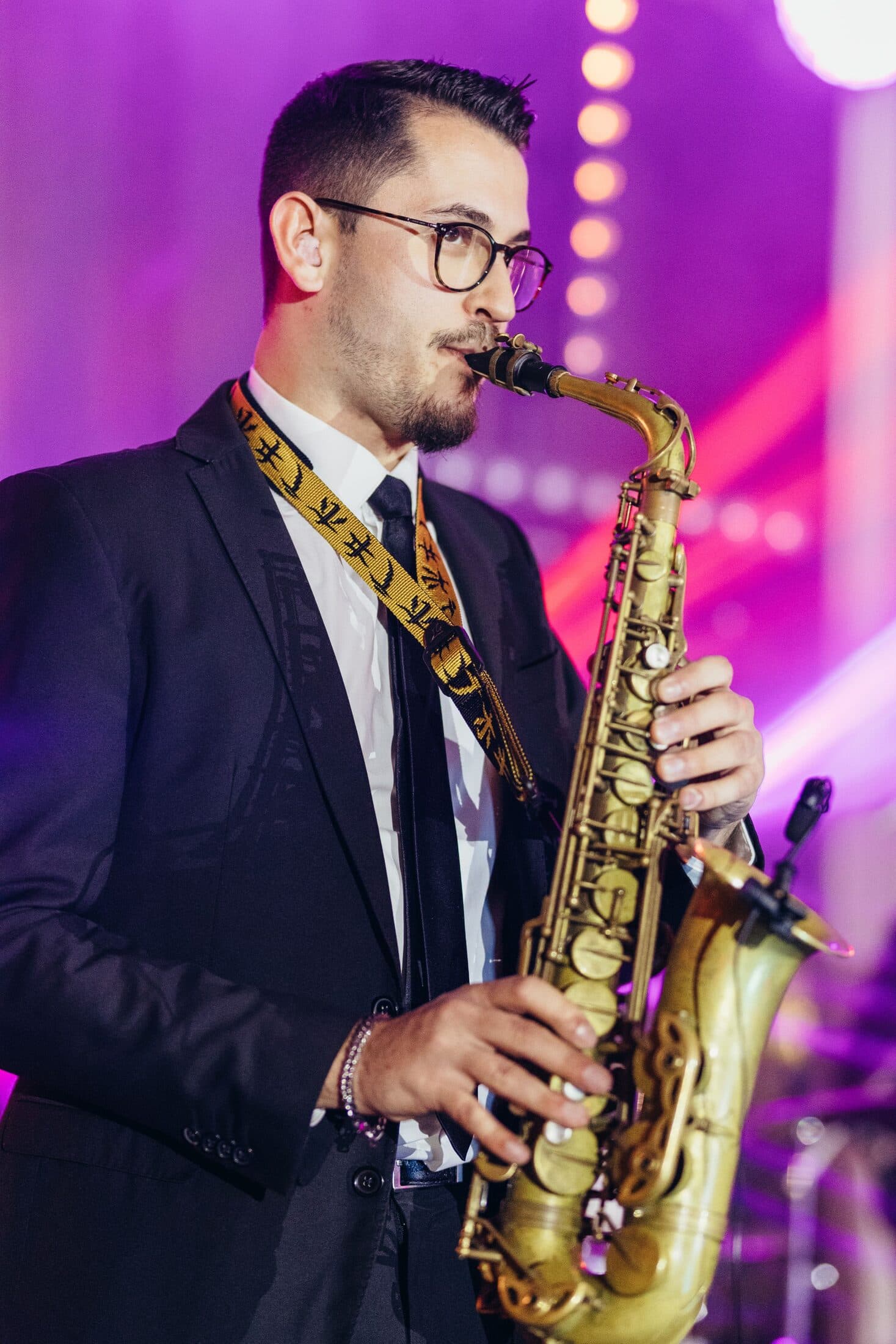 Saxofonista a atuar com iluminação de palco numa festa